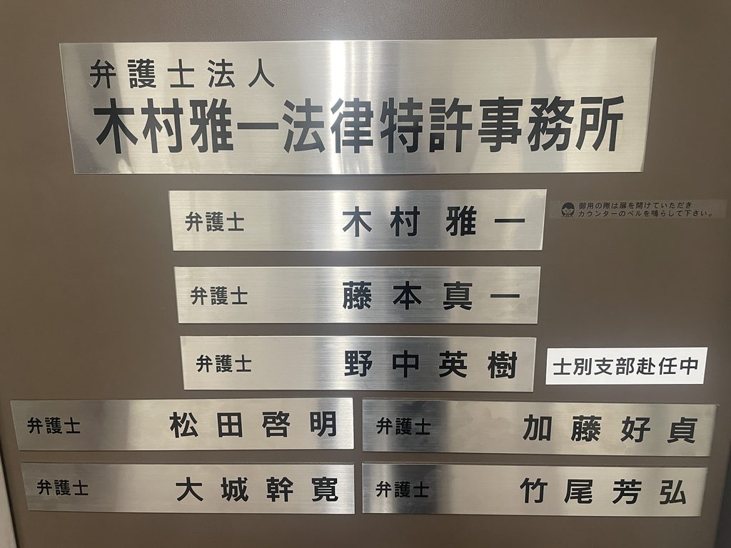 木村雅一法律特許事務所 八王子本部の事務所名と所属弁護士名が並ぶ入口看板