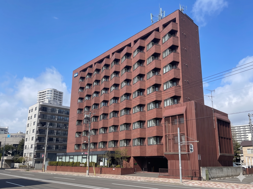 青空の下に立つ木村雅一法律特許事務所 札幌支部が入るレンガ調の建物外観